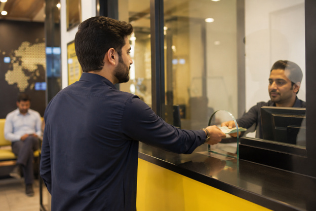 Pakistani expatriate sending money to family in Pakistan from a UAE remittance centre, highlighting the role of overseas remittances in supporting households and investment.