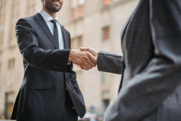 Two people in suits shaking hands