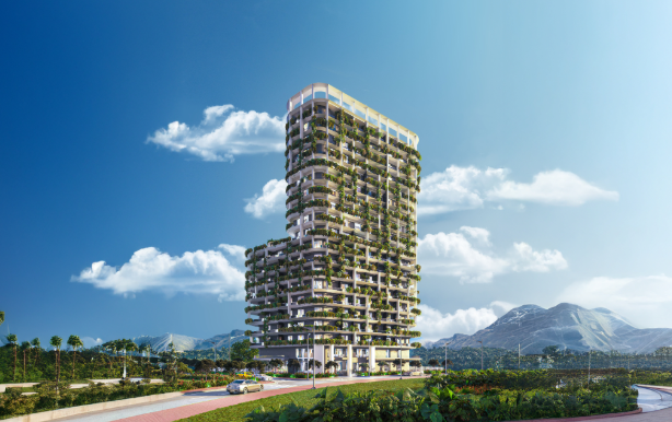 A building stands tall with greenery covering the facade against a blue sky with mountains visible in the distance and foliage all around