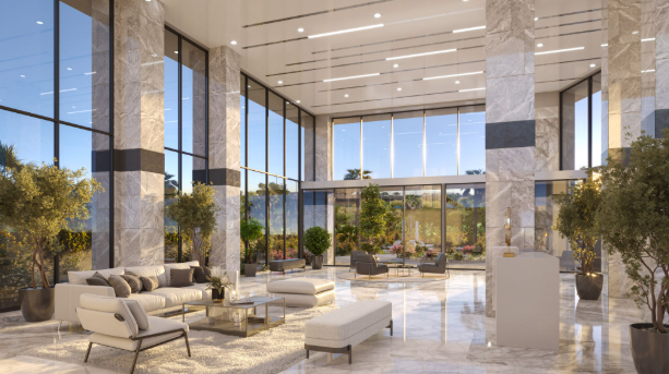 A luxurious hotel-style lobby with seating spread out over marble floors and tall pillars amidst planters with small trees in them