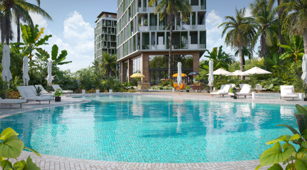 A large pool surrounded by foliage sprawls out in front of a residential apartment building