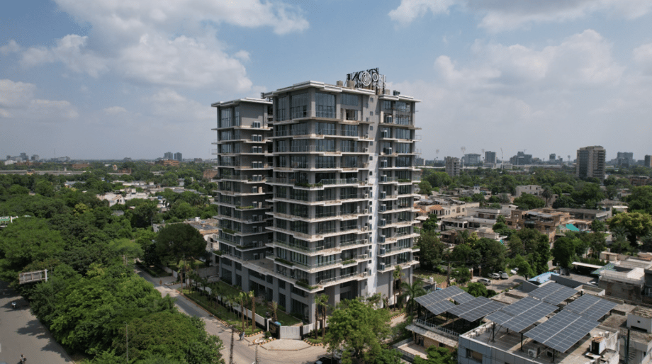CGI view of One Canal Road rising above Lahore’s lush greenery under a clear blue sky, symbolising premium luxury apartments in Pakistan designed for overseas investors seeking lifestyle and stability.