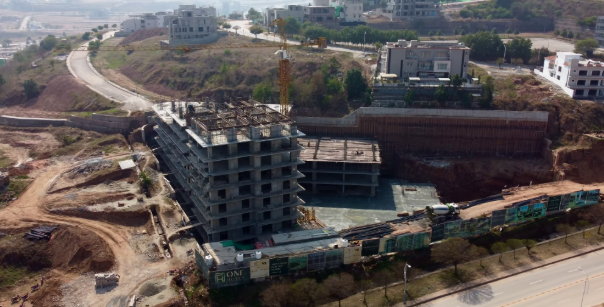 An aerial photo of a building under construction with city views in the distance