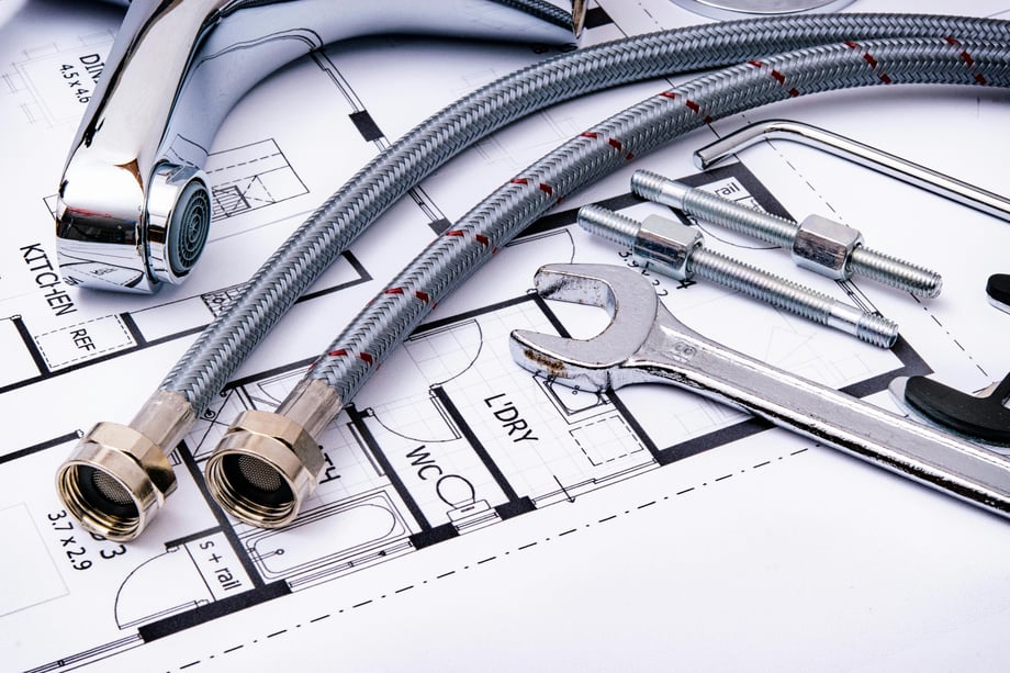 Plumbing equipment and tools on a blueprint