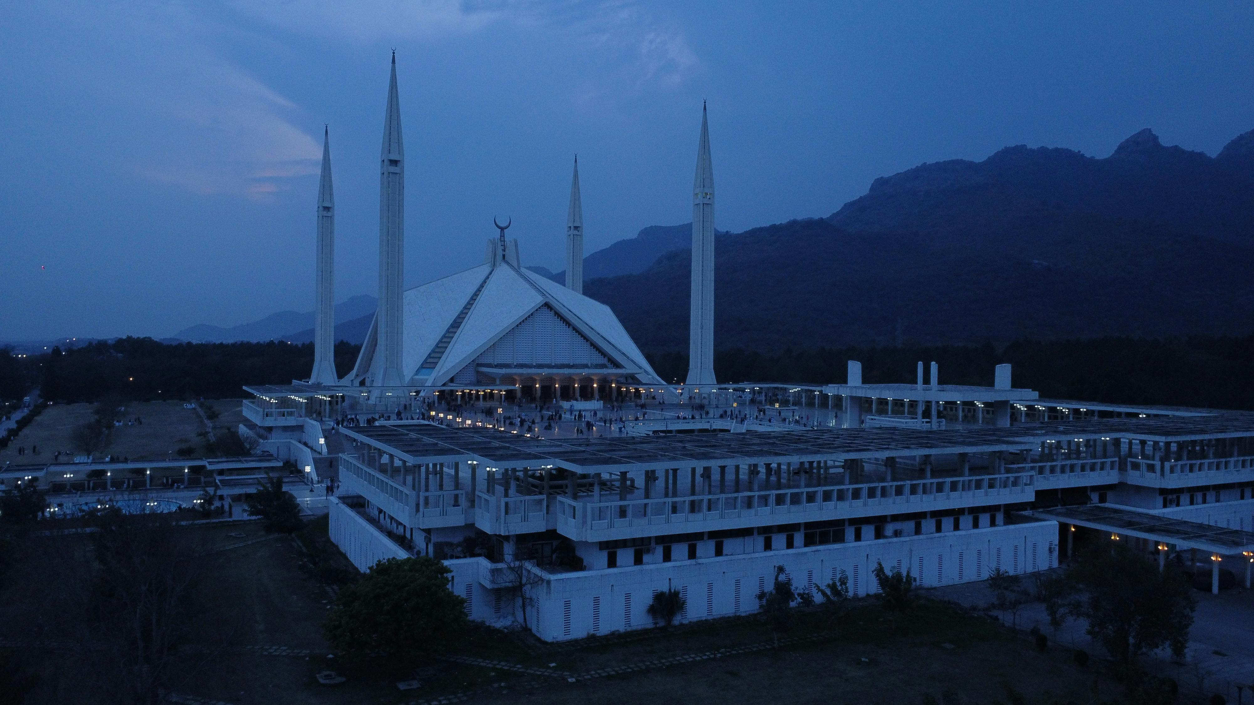  A view of the Faisal Mosque against silhouettes of mountains in the late evening light