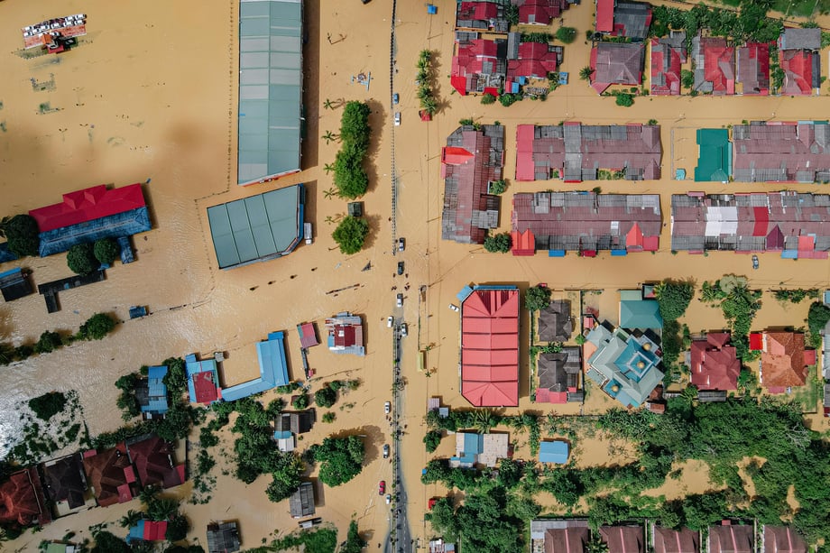 A small village with residential houses surrounded by floodwater.