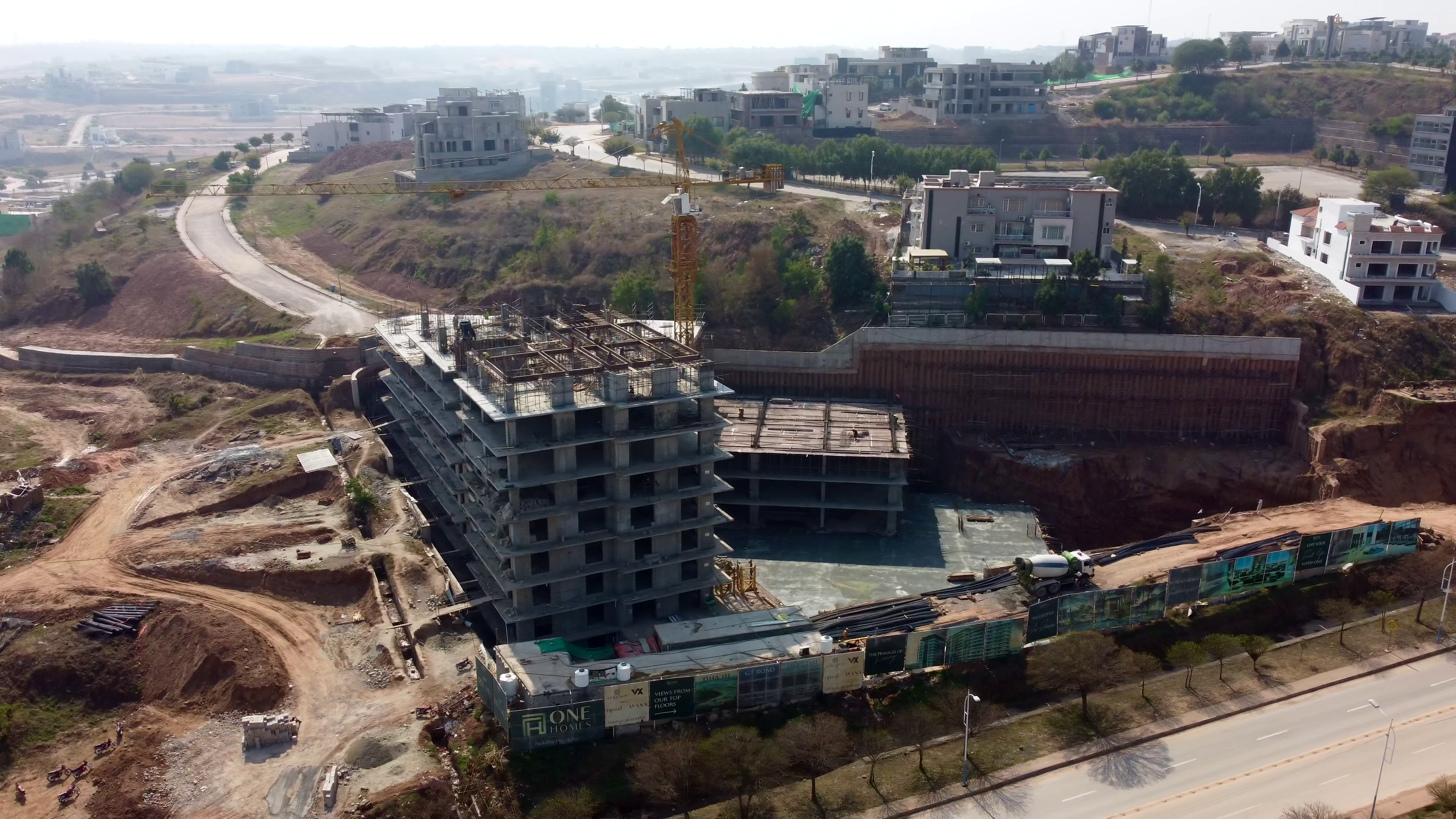 An aerial photo of a building under construction with city views in the distance